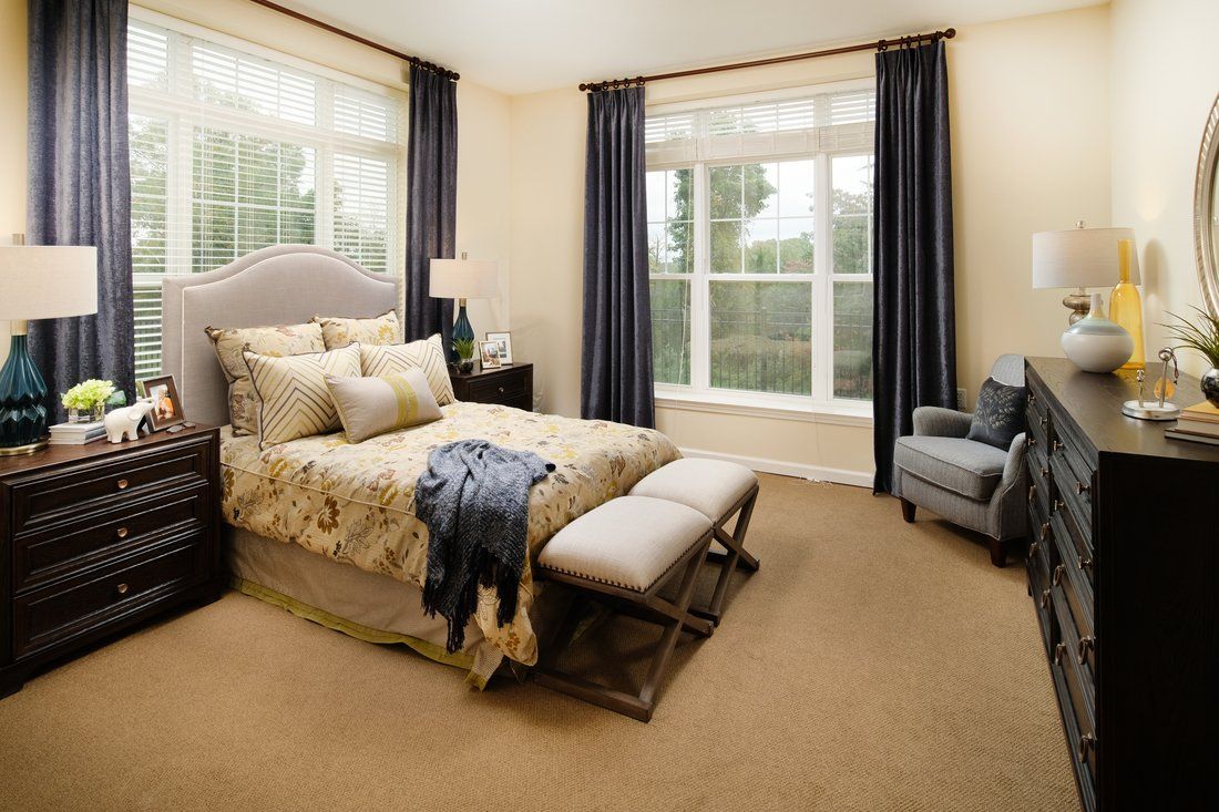 Modern and cozy bedroom with elegant decor and large windows.