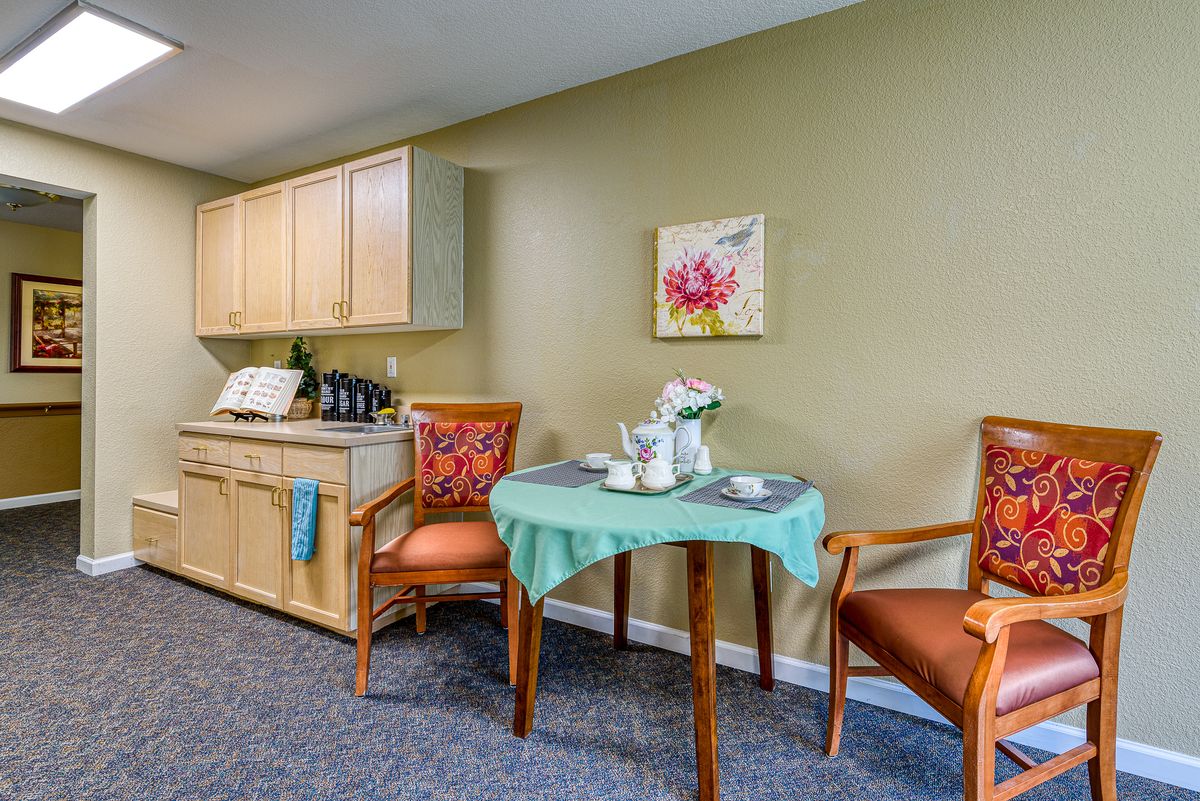 A cozy kitchen and dining area with a small table, chairs, and decorative elements.