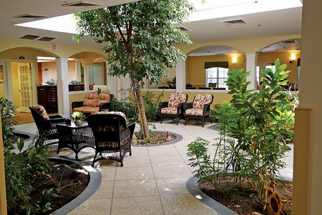 A serene indoor garden with comfortable seating and lush greenery.