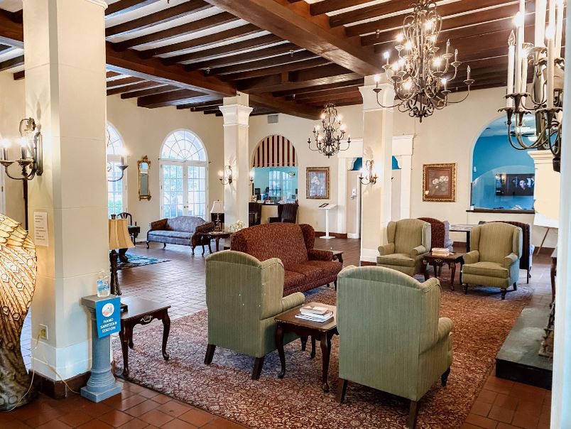 A spacious lobby with comfortable seating and elegant chandeliers.