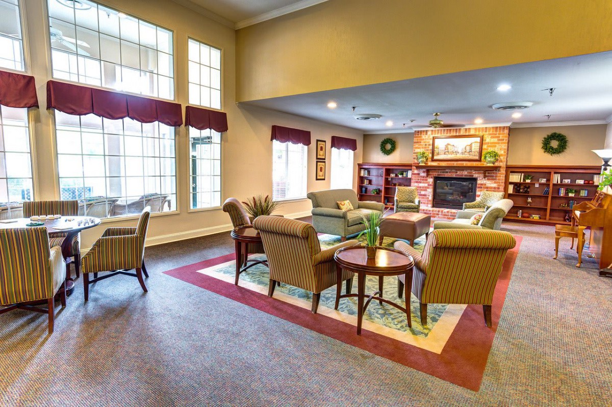 A cozy living room with comfortable seating and a fireplace, featuring large windows that let in natural light.