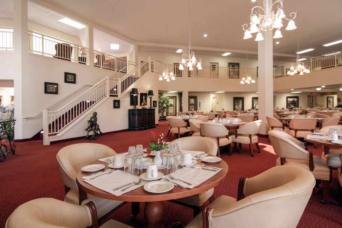 Elegant dining area with round tables, comfortable seating, and warm lighting.
