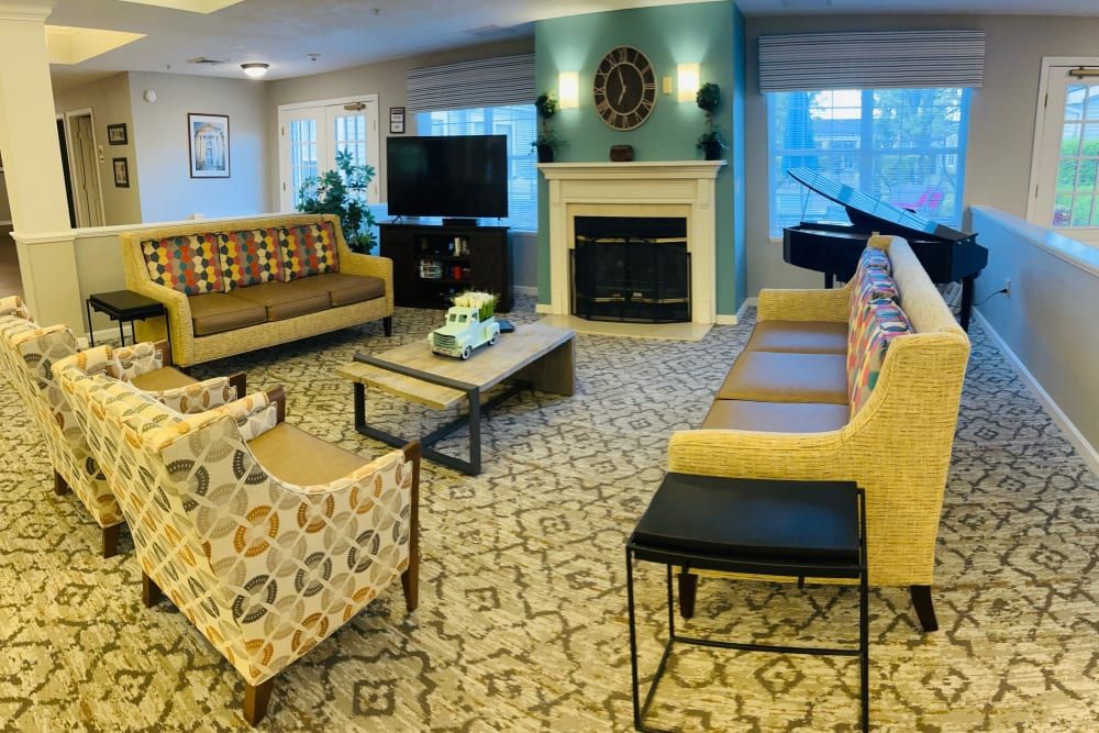 A cozy living room with modern decor, featuring a fireplace, comfortable seating, and a television.