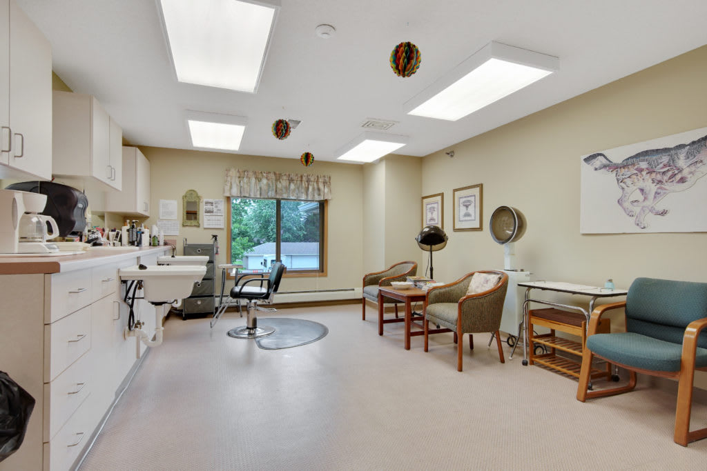 A well-lit doctor's office with seating and medical equipment.