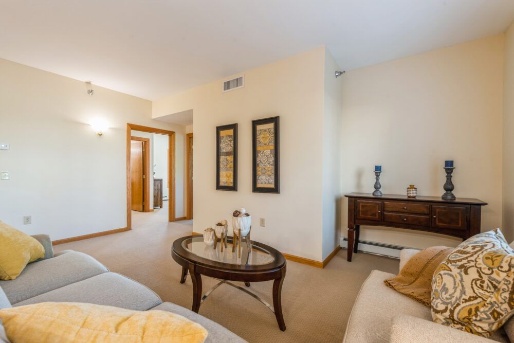 A cozy living room featuring a stylish coffee table, comfortable sofa, and wall art decor.