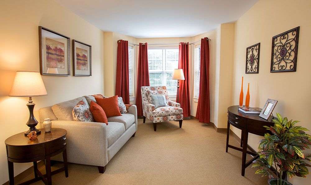 A cozy living room with a sofa, an armchair, and warm-colored decor.