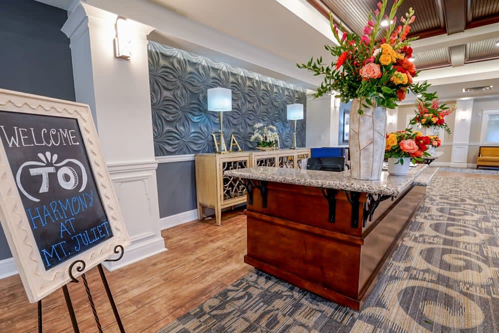 A modern and stylish lobby with a reception desk adorned with flowers.