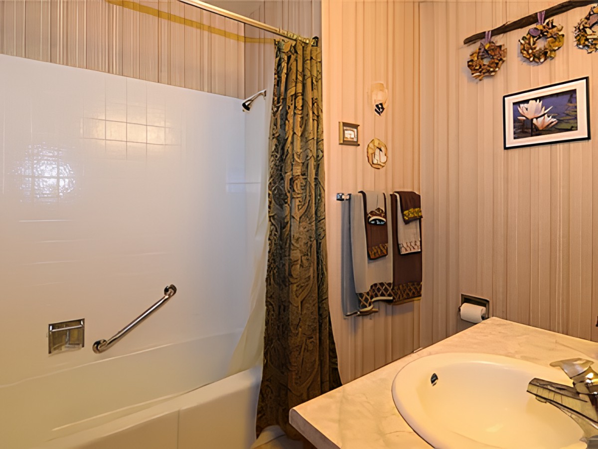 A cozy bathroom with a bathtub, shower curtain, and neatly arranged towels.