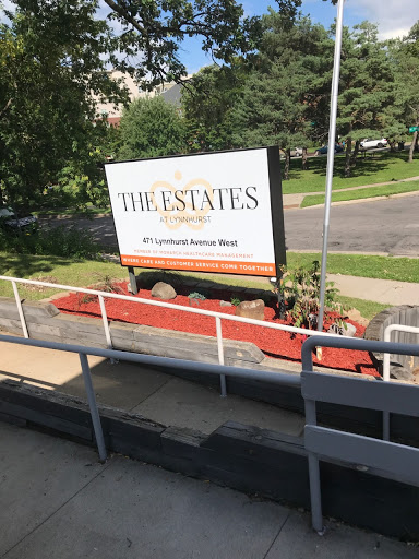 A community sign for 'The Estates' displayed in an outdoor setting.