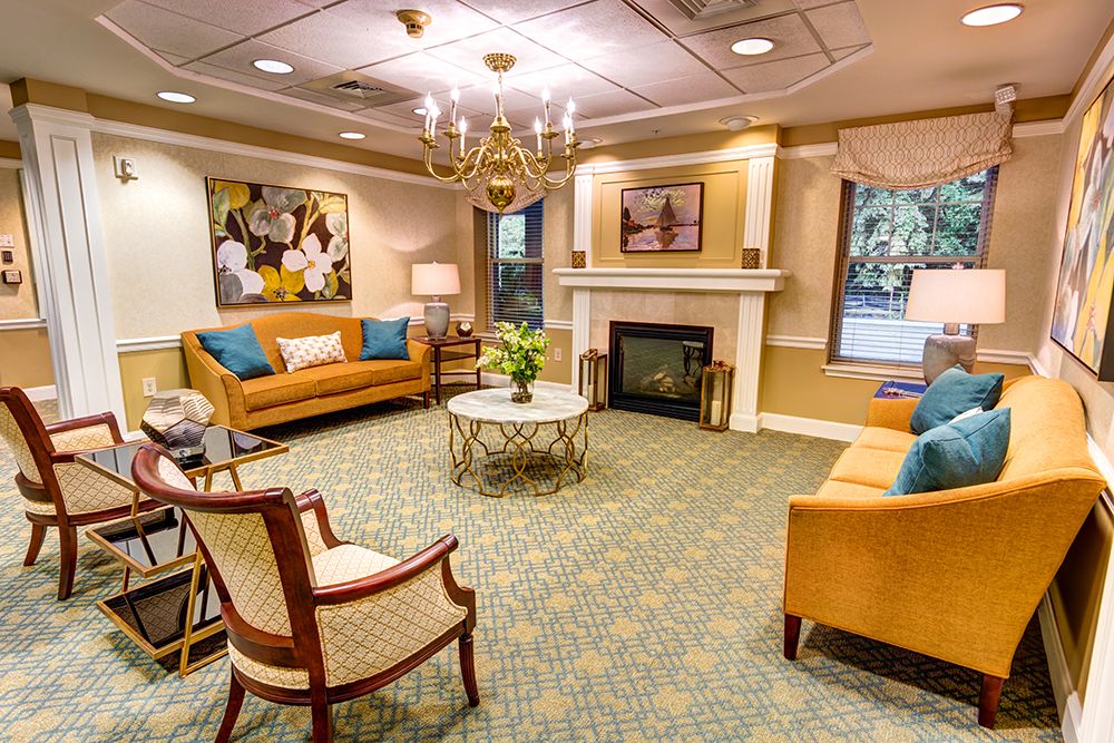 A cozy living room with sofas and a fireplace, elegantly decorated with warm tones.