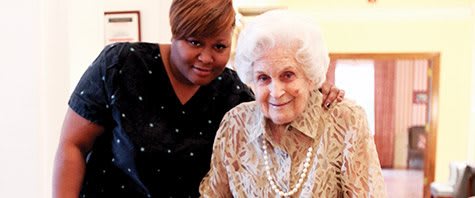 Two women smiling together indoors.