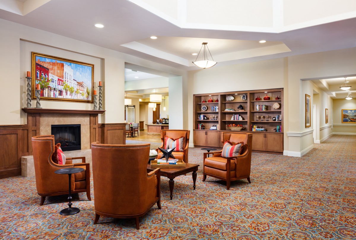 A cozy lobby with comfortable seating, bookshelves, and a warm ambiance.