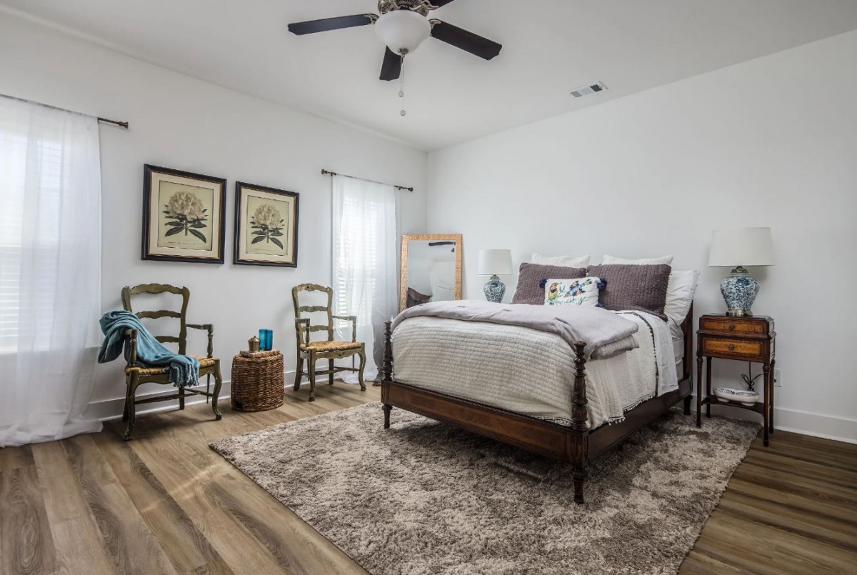 A cozy bedroom with a stylish interior design featuring a comfortable bed, wooden flooring, and elegant decor.