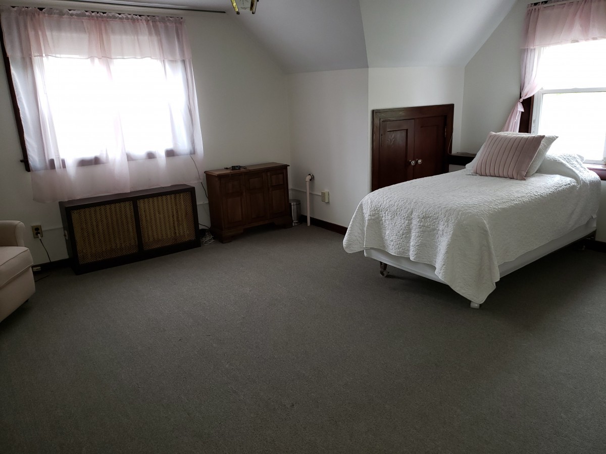 A minimalist bedroom with a single bed and natural lighting.