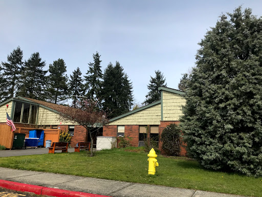 A view of a residential area featuring houses, trees, and a yellow fire hydrant.