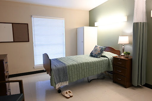 A cozy and well-arranged bedroom featuring a bed, dresser, and natural light.