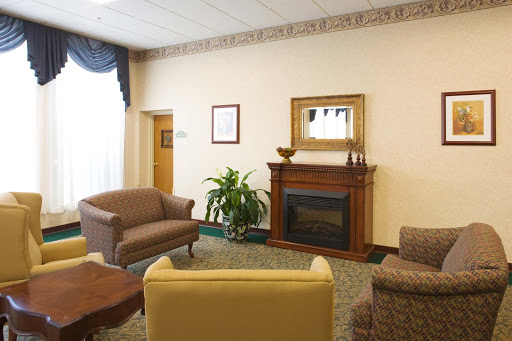 A cozy living room featuring comfortable seating, a wooden fireplace, and decorative elements.