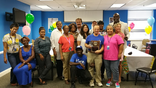 A group of colleagues celebrating a special occasion in an office setting.