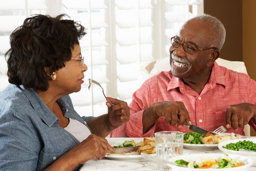 A couple enjoying a meal together at home, engaged in pleasant conversation.