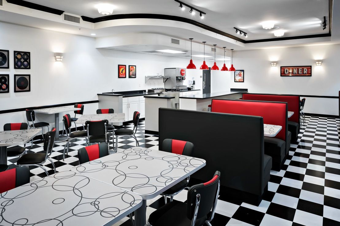 A retro-themed diner with checkerboard flooring and red accents.