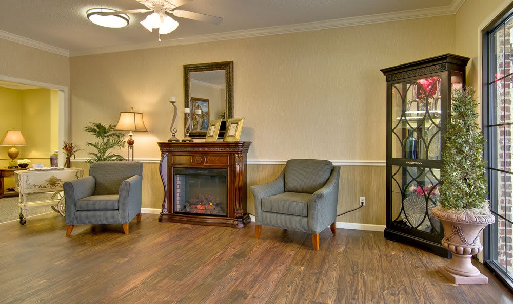 A cozy living room with a fireplace, armchairs, and elegant decor.