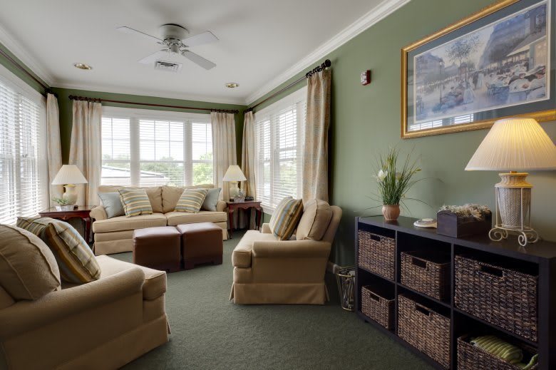 A cozy living room with comfortable sofas and armchairs, large windows, and tasteful decor.