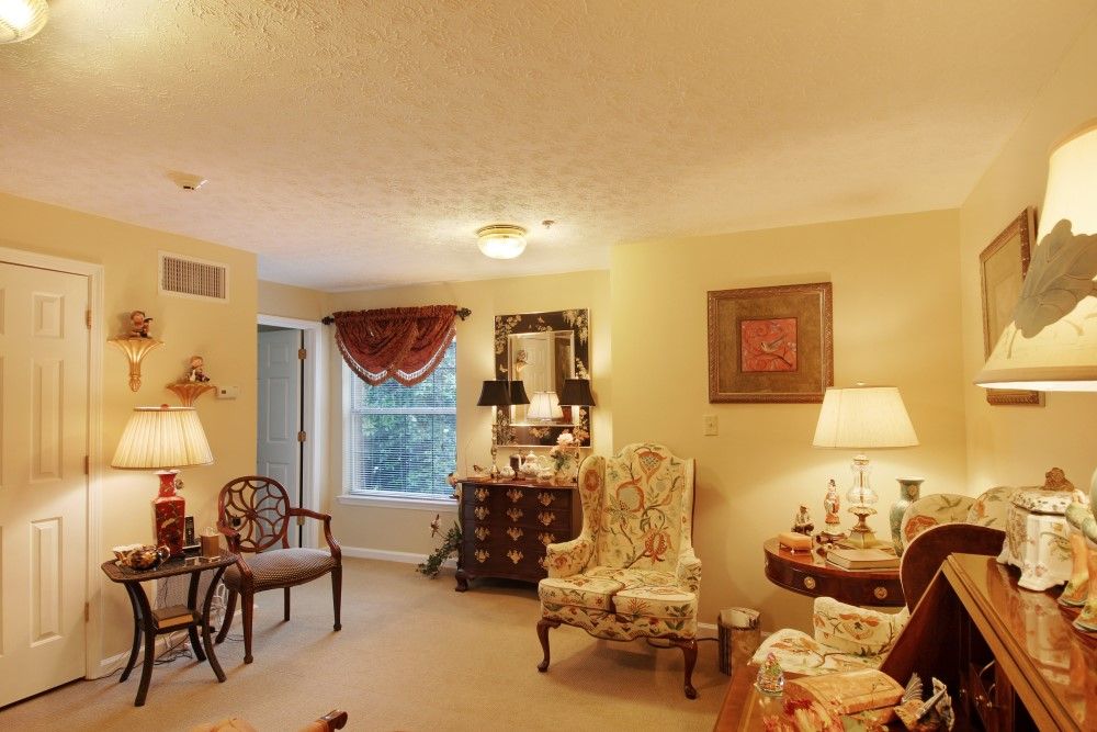 A traditionally decorated living room with armchairs, a mirror, and ambient lighting.