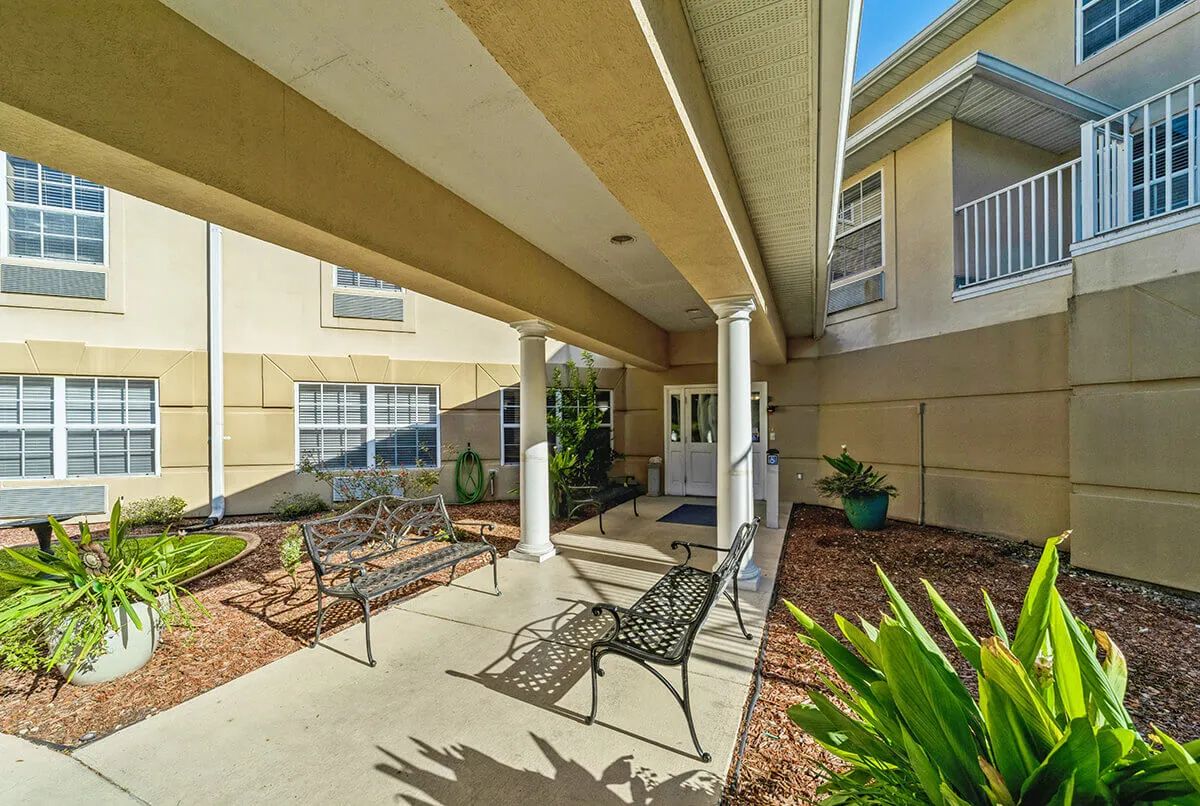A covered patio area with benches outside a building.