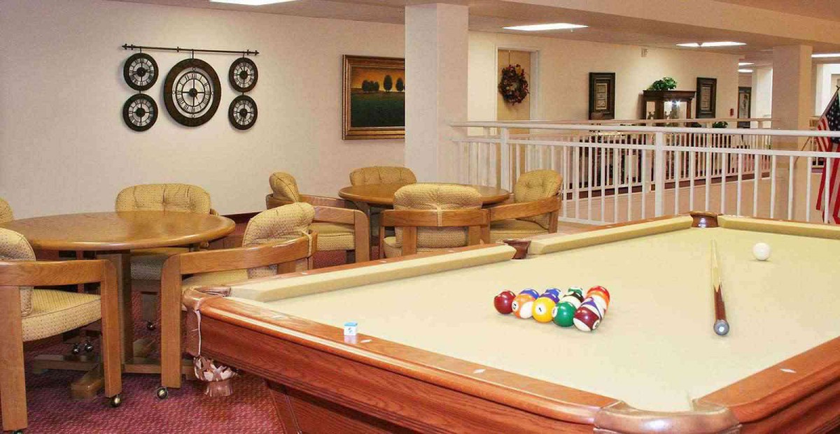 A cozy lounge area featuring a billiards table and comfortable seating arrangements.