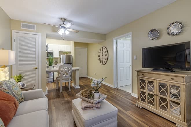 A cozy modern living room with a view into the kitchen, featuring elegant decor and comfortable furniture.