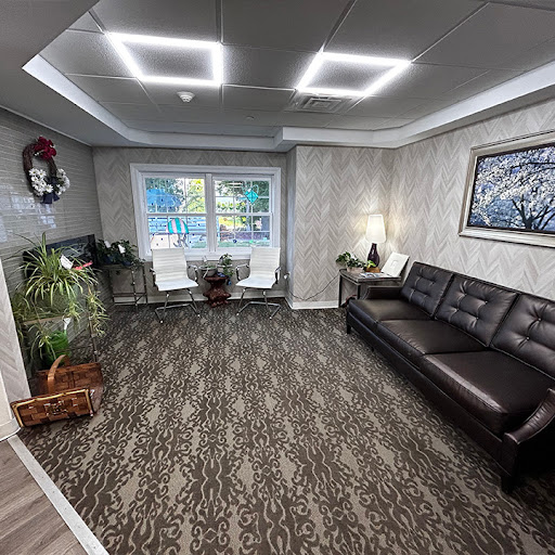 A modern and inviting waiting room featuring sleek furniture and natural elements.