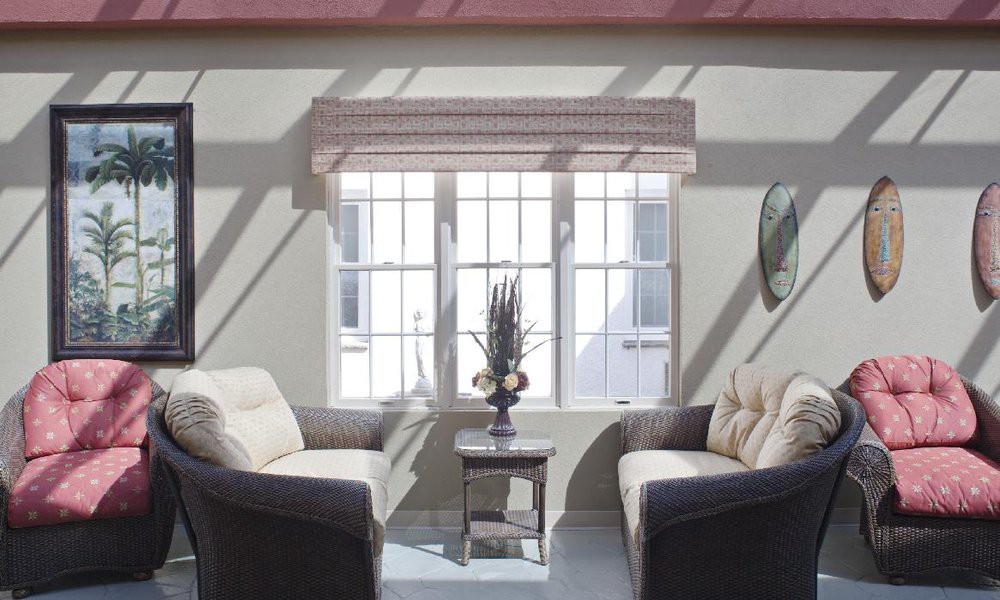 A bright living room with two sofas facing each other, a small coffee table in between, and sunlight streaming through a large window.