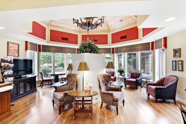 A cozy living room with comfortable seating, elegant lighting, and abundant natural light from large windows.