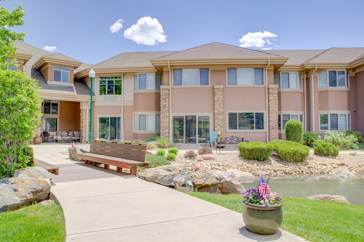 A two-story residential building with landscaped surroundings on a sunny day.