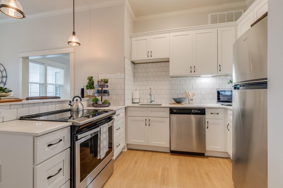 A modern kitchen with white cabinets, stainless steel appliances, and a subway tile backsplash.