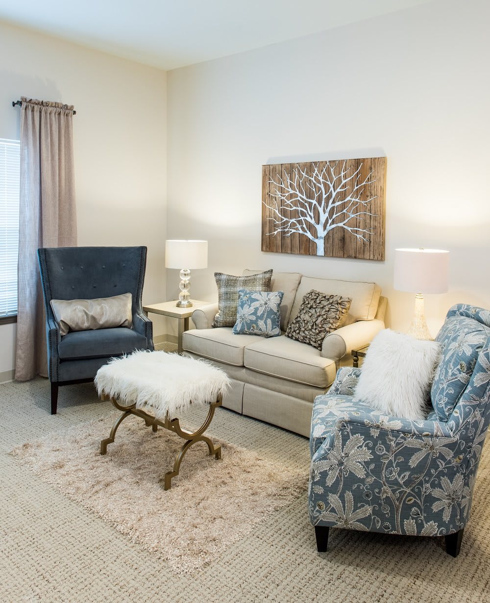 A cozy living room with elegant furniture and artwork on the wall.