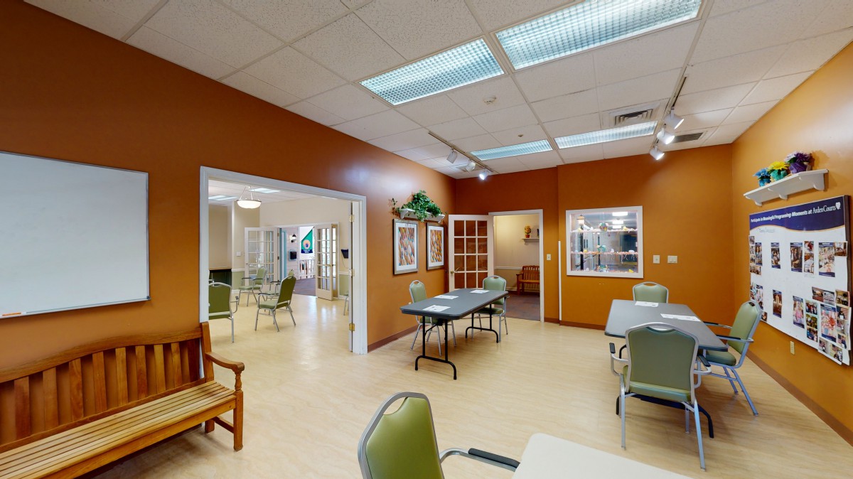 A spacious interior with tables and chairs, featuring warm lighting and decor.