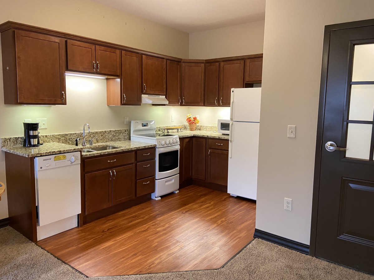 Modern kitchen with wooden cabinets and appliances in an apartment.