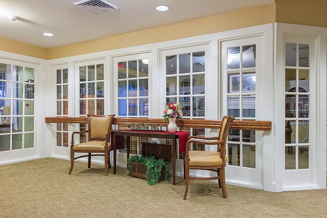 A cozy indoor seating area with chairs and a table positioned near glass doors.