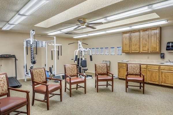 A small exercise room with gym equipment and seating area.