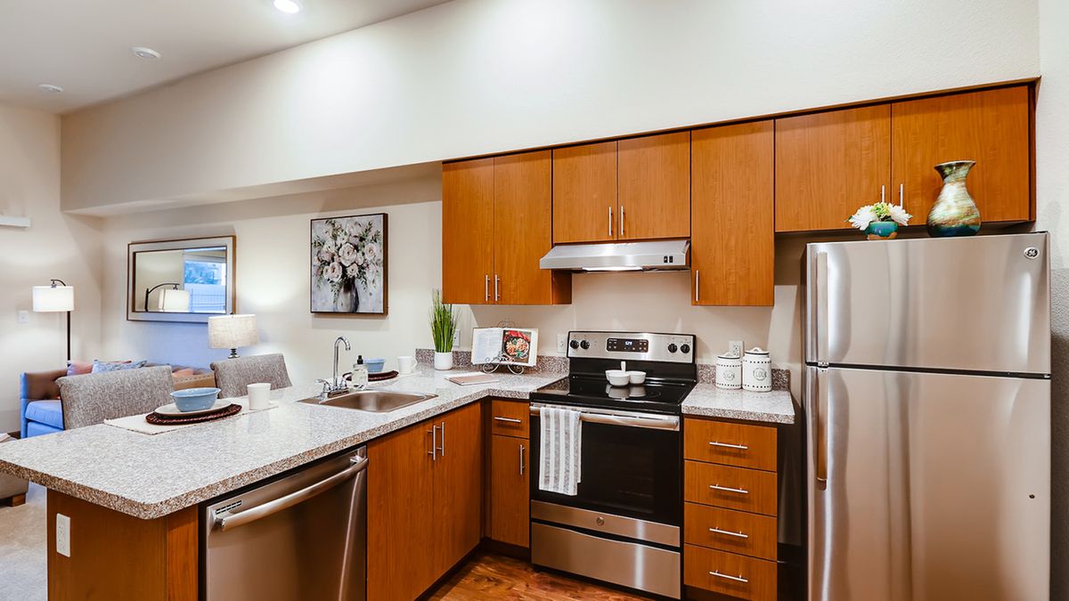 A modern kitchen with wooden cabinets and stainless steel appliances.