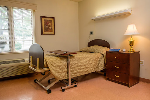 A comfortable hospital patient room with a bed, bedside table, and window.