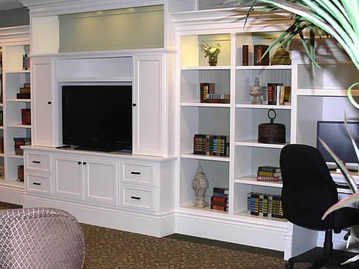 White entertainment center with built-in bookshelves and television in a cozy living room setting.
