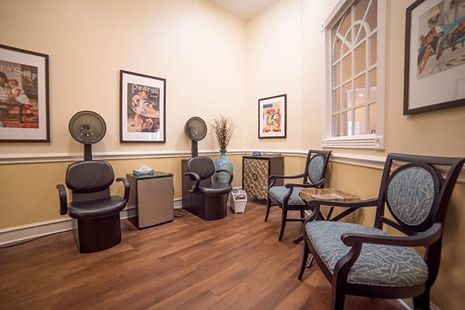 A cozy waiting room with elegant chairs, artwork on the walls, and a calming atmosphere.