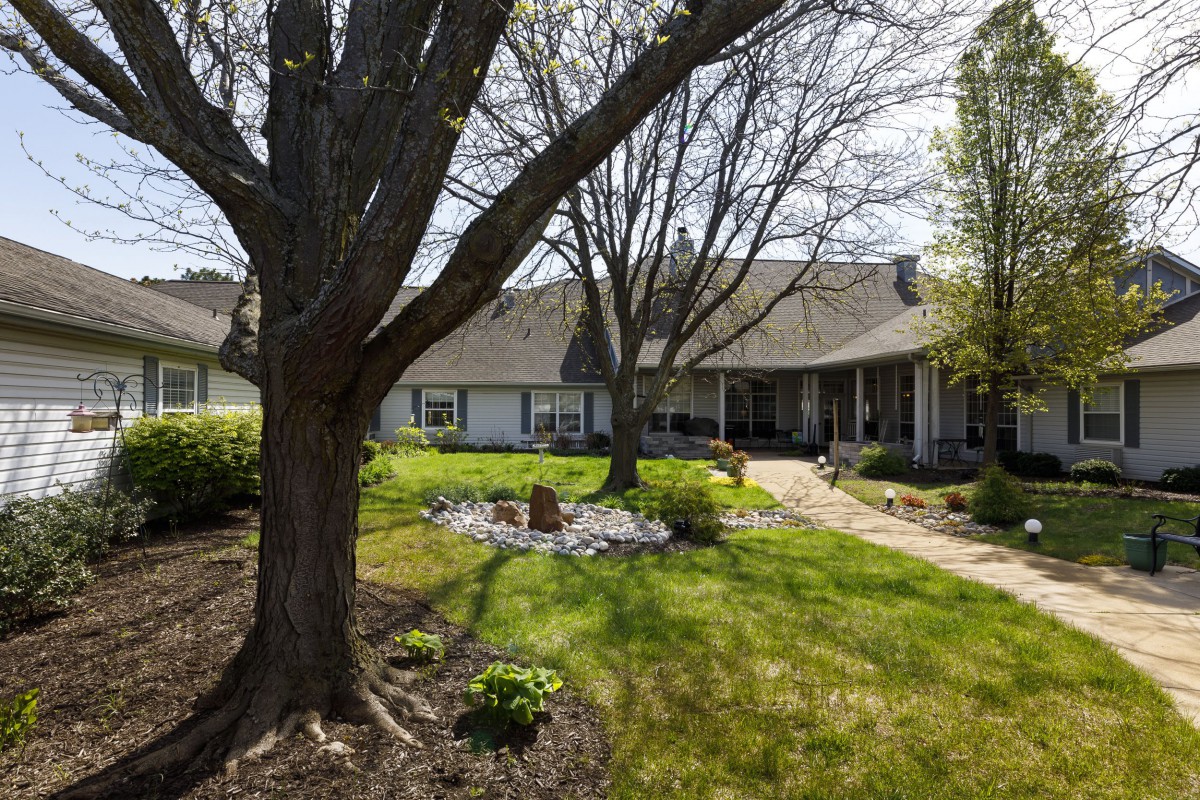 A residential house surrounded by a well-maintained yard and trees in spring.