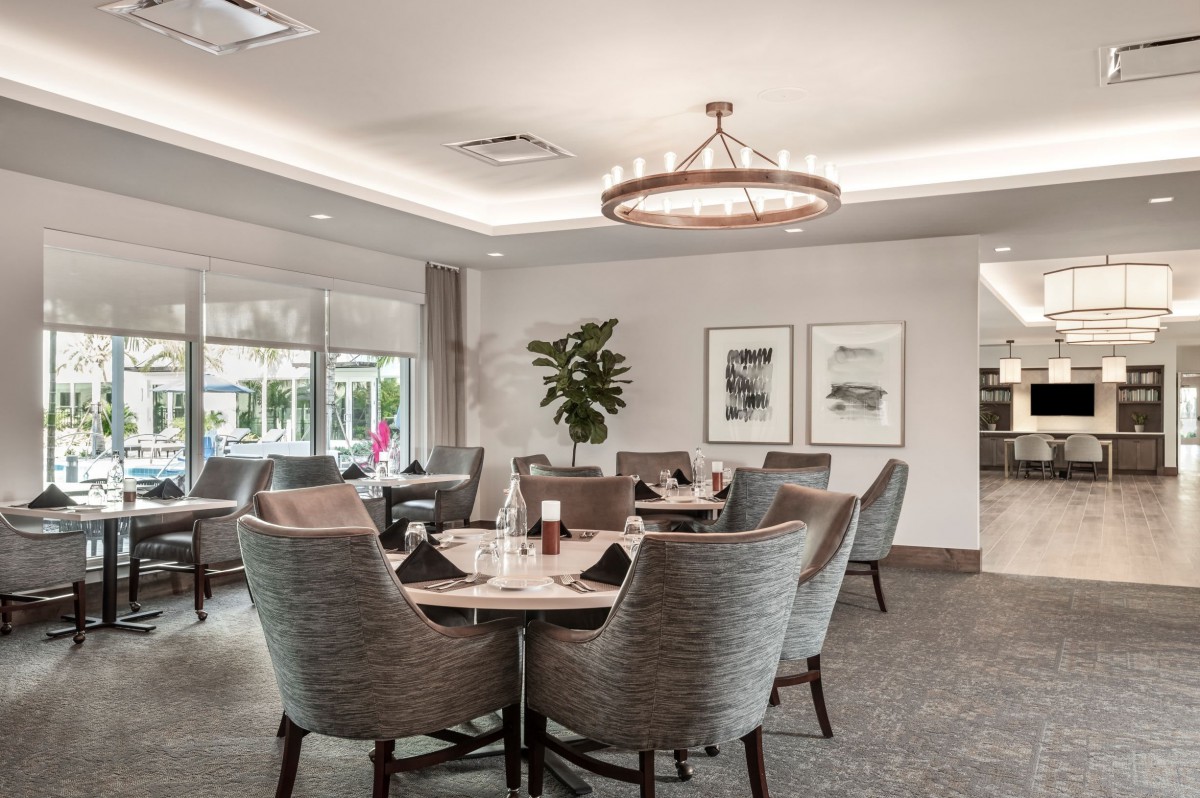 A modern and elegant dining room with stylish seating and a chandelier.
