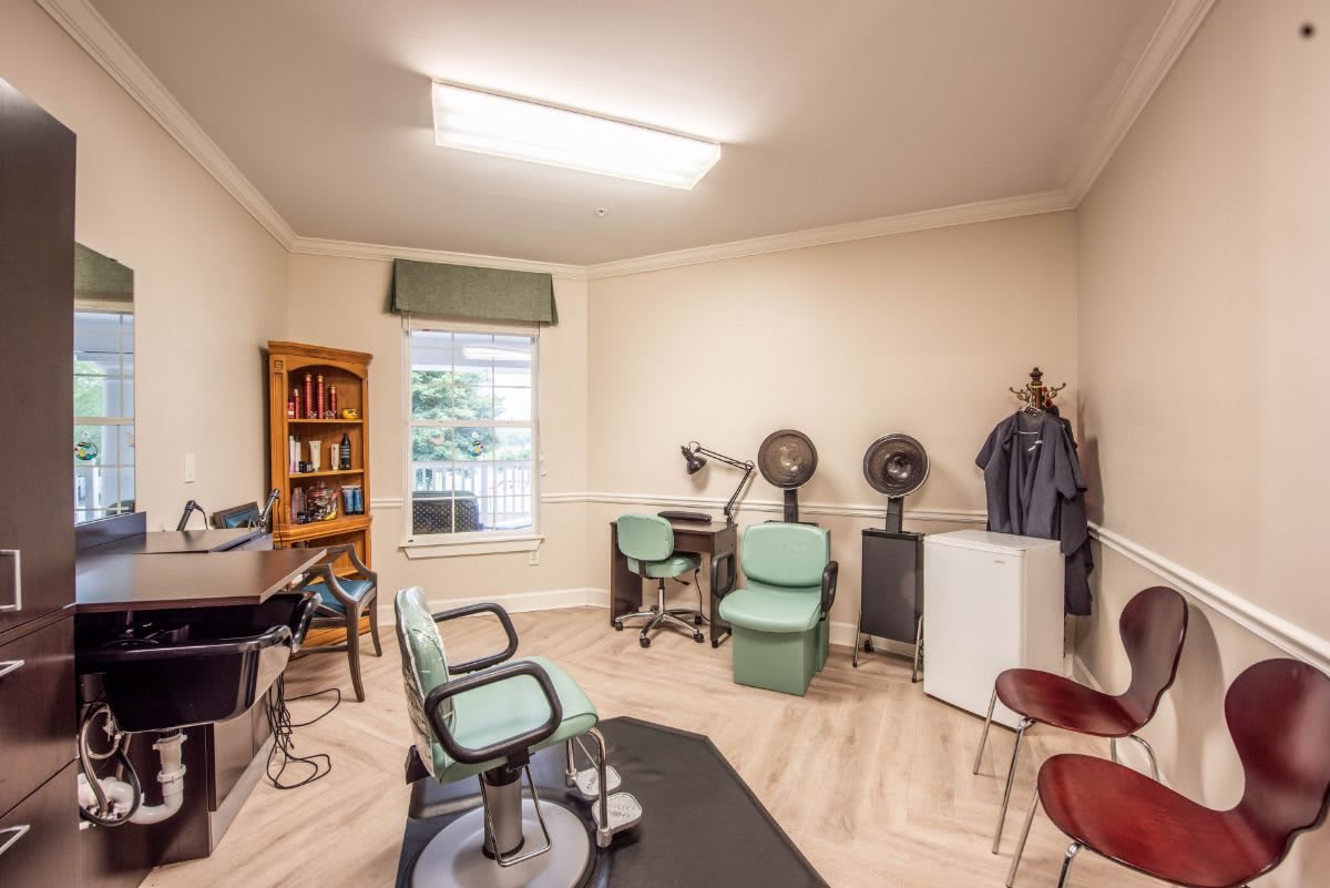 A vintage-style hair salon interior with chairs and hair drying equipment.