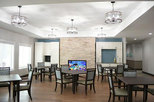 A modern dining room featuring elegant furniture, ample lighting, and a television.