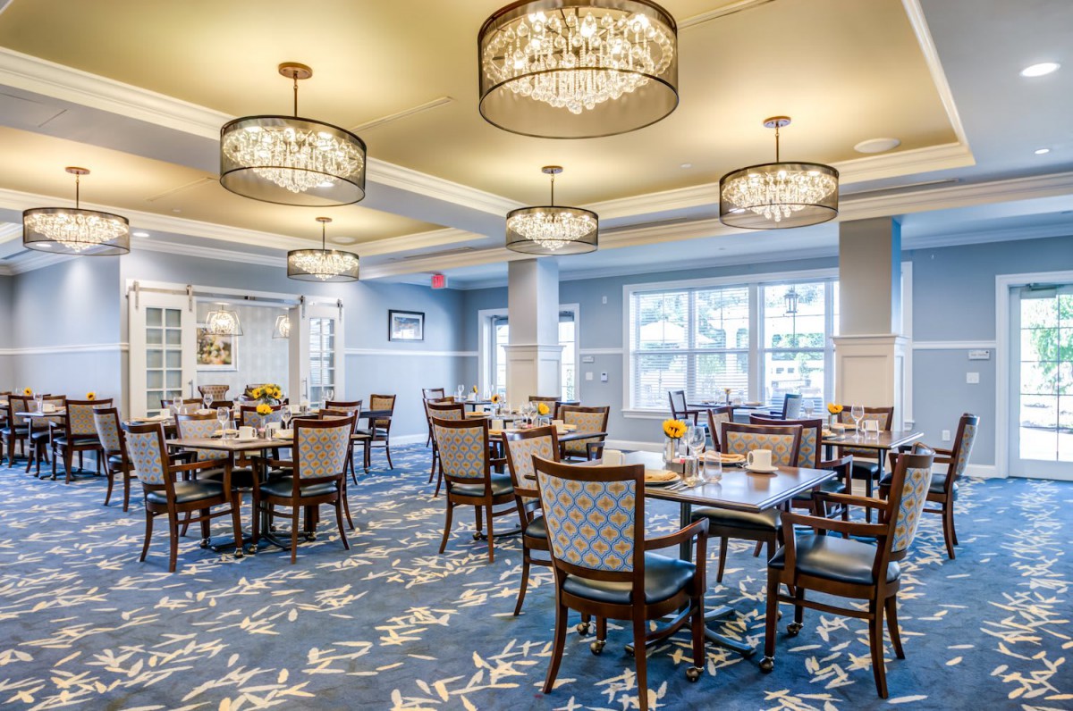 A beautifully decorated dining room with elegant chandeliers and neatly arranged tables.
