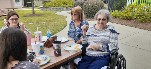 A lovely picnic gathering in the park with friends enjoying a meal together.